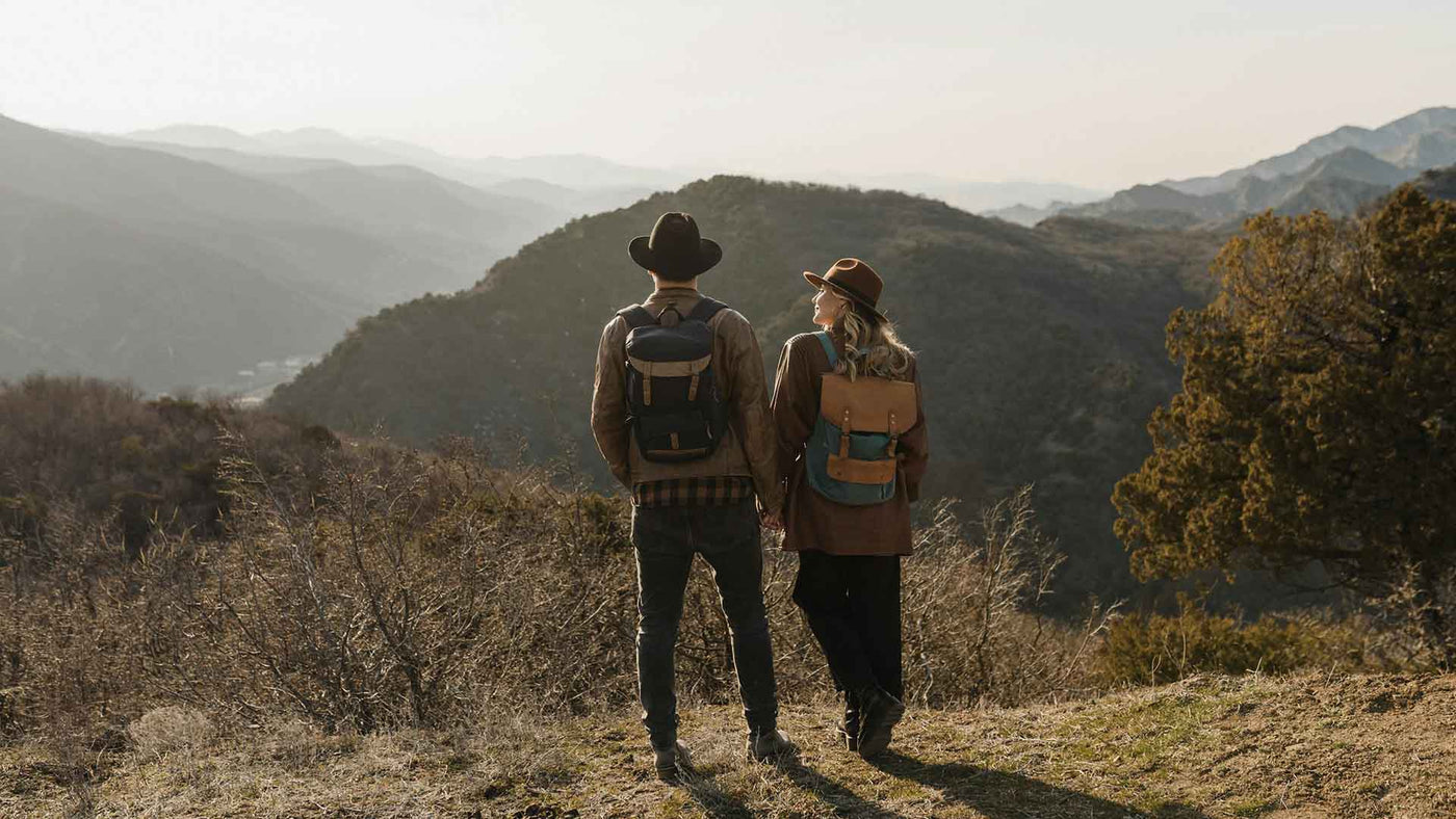 couple holding hands standing on mountain hill