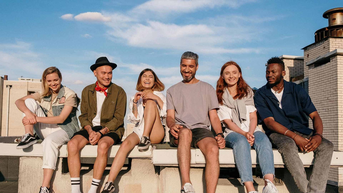 group of friends hanging out while sitting on a bench on a rooftop