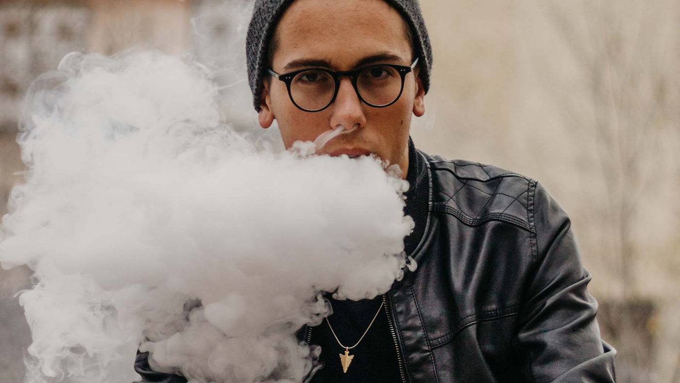 man in a black leather jacket exhaling vapor