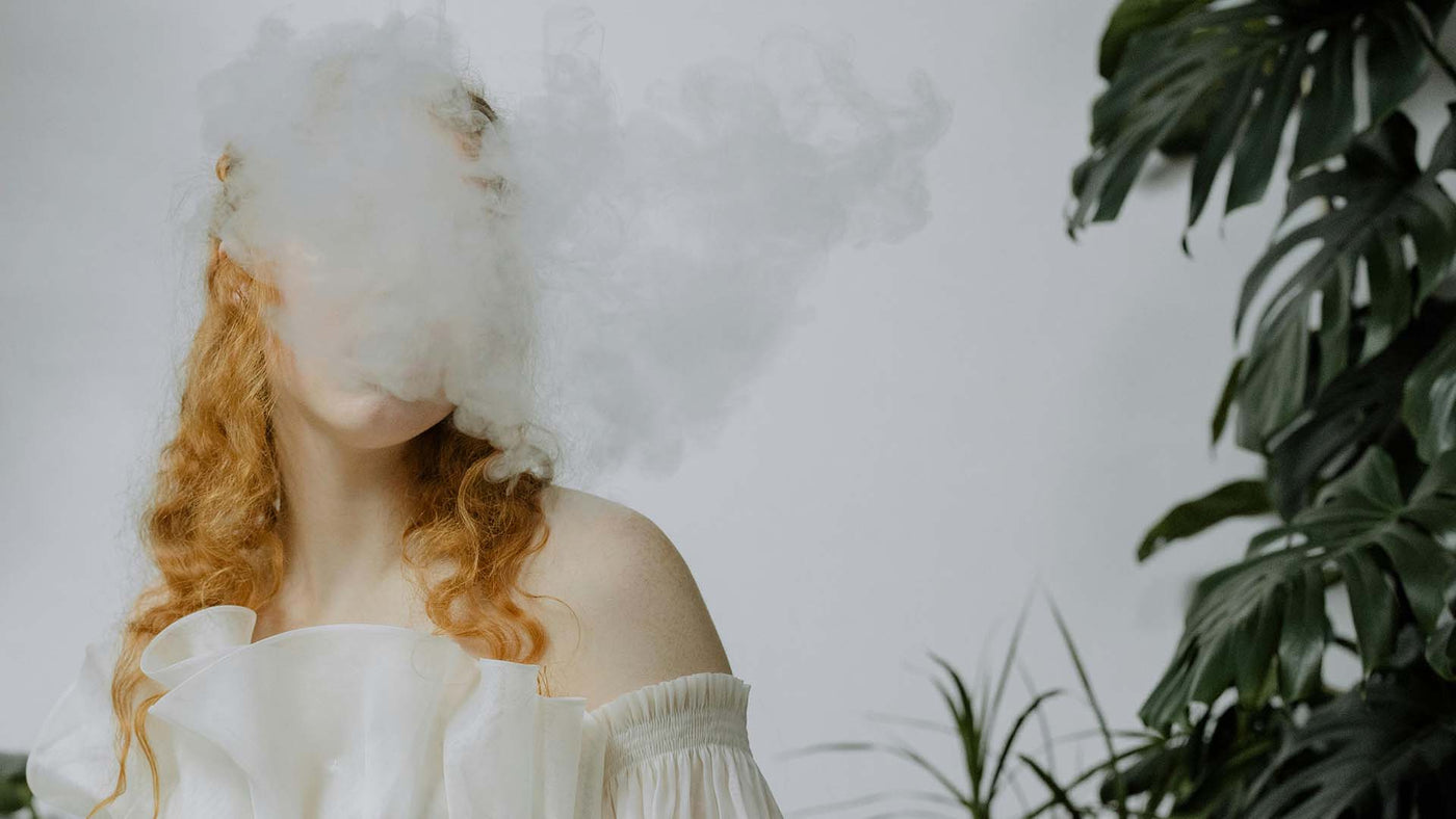 a red-haired woman behind a smoke