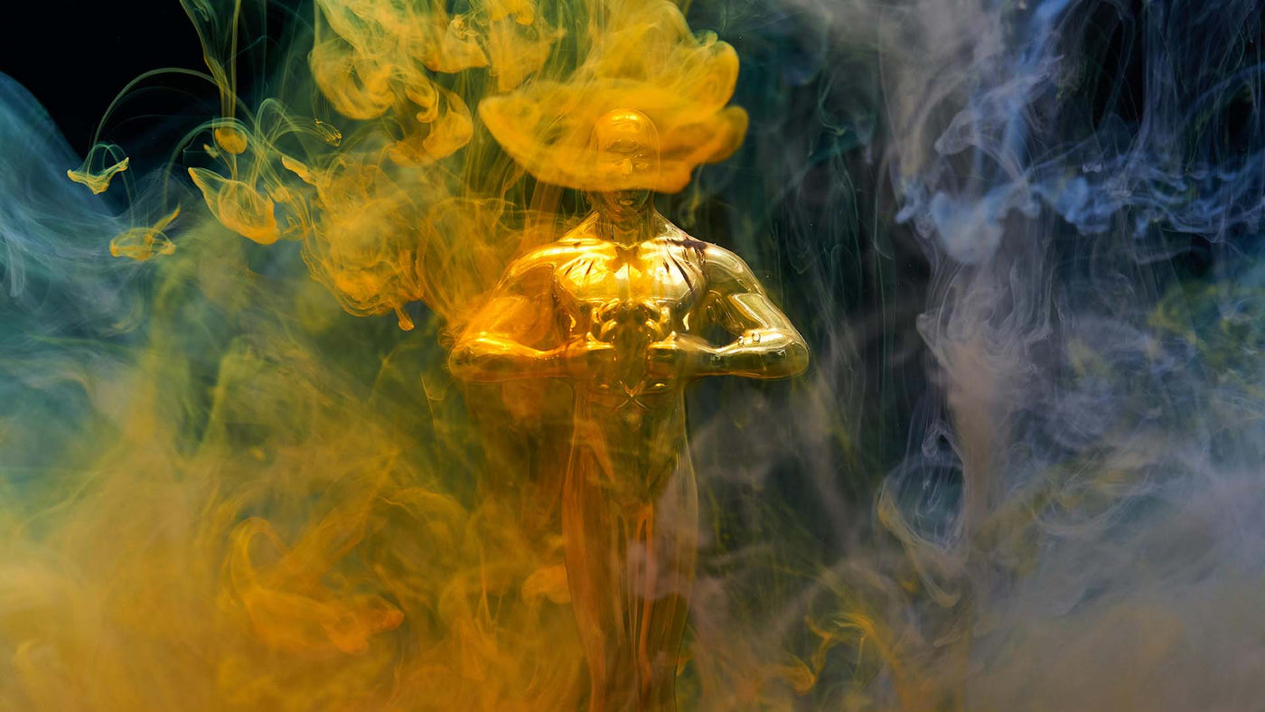 gold statue surrounded with colorful smoke