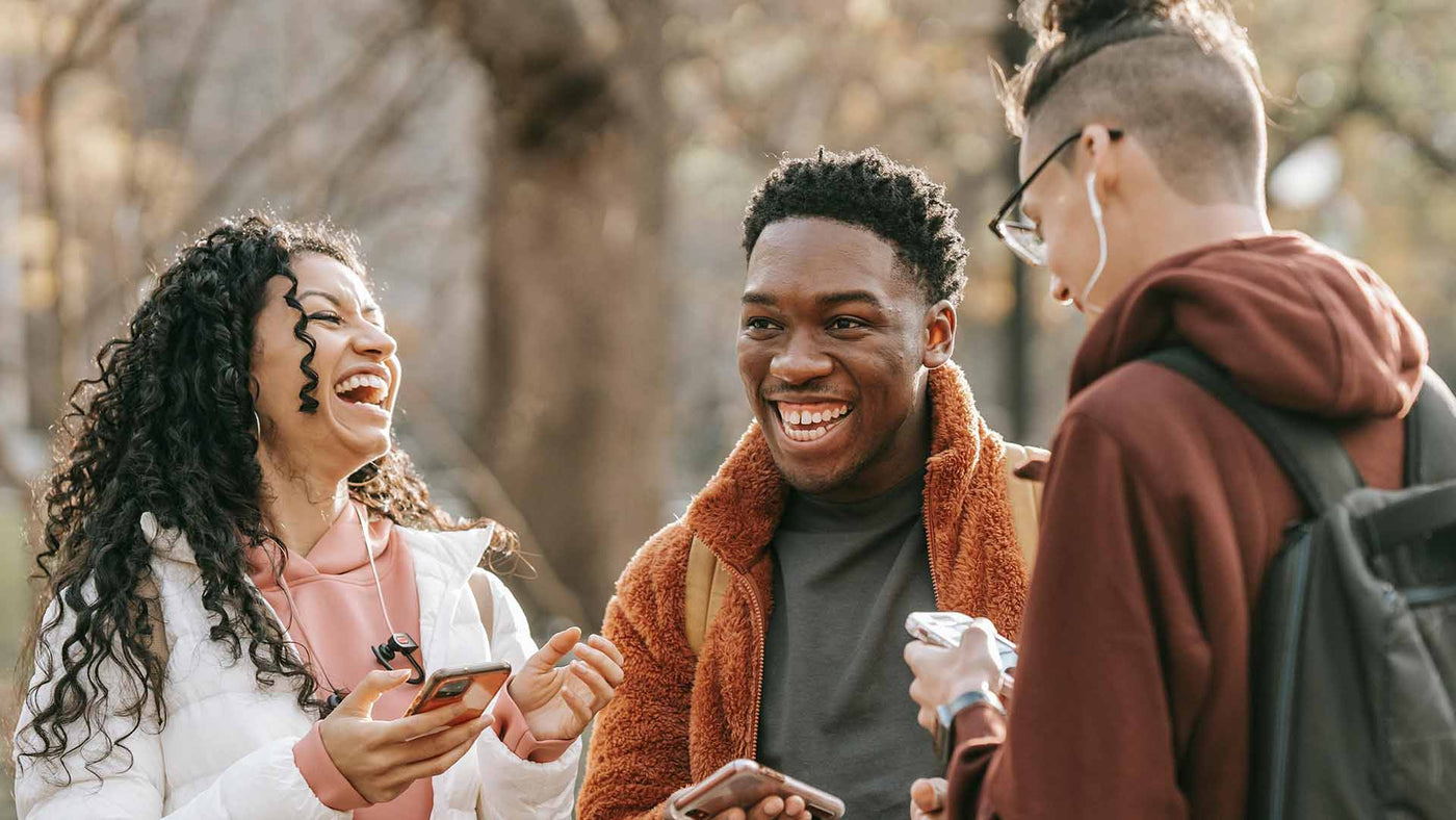 Three friends laughing together outside