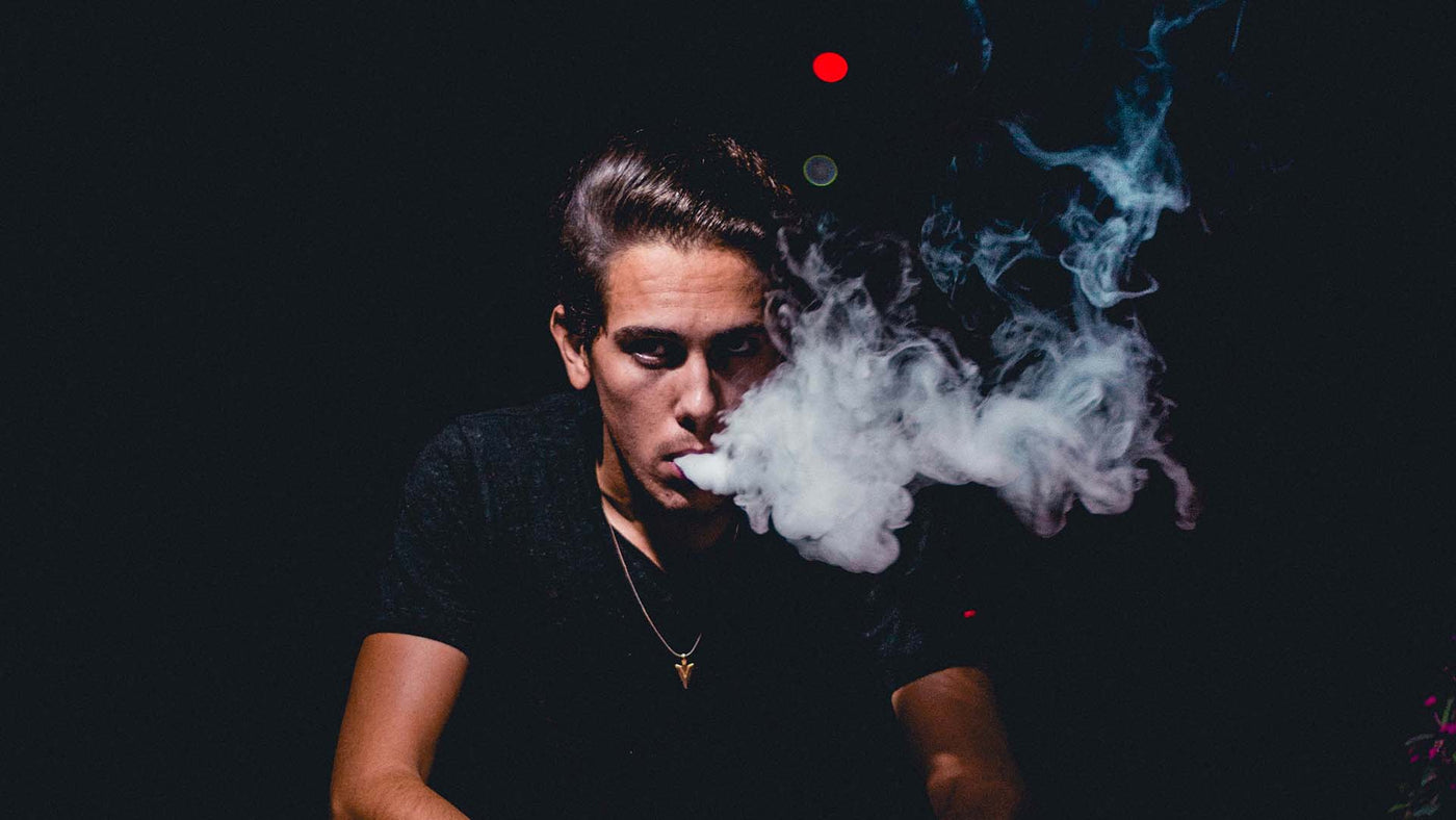 person smoking while squatting during night time