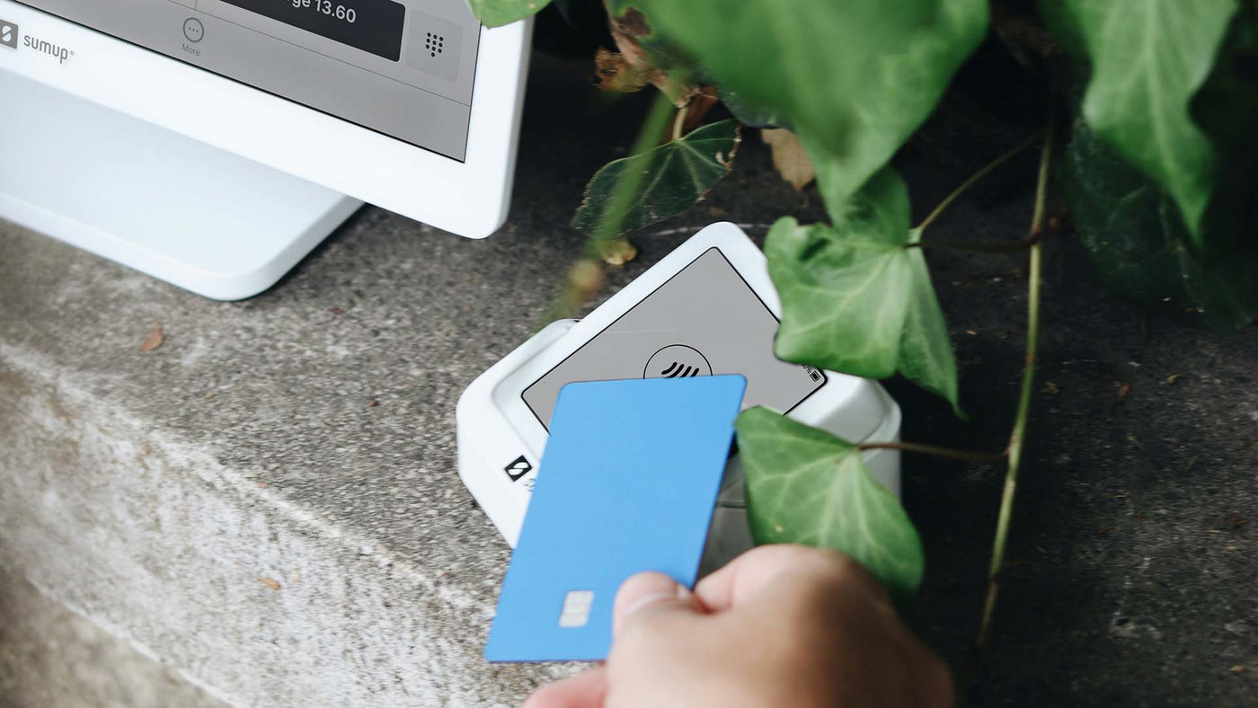 a person holding a credit card next to a computer