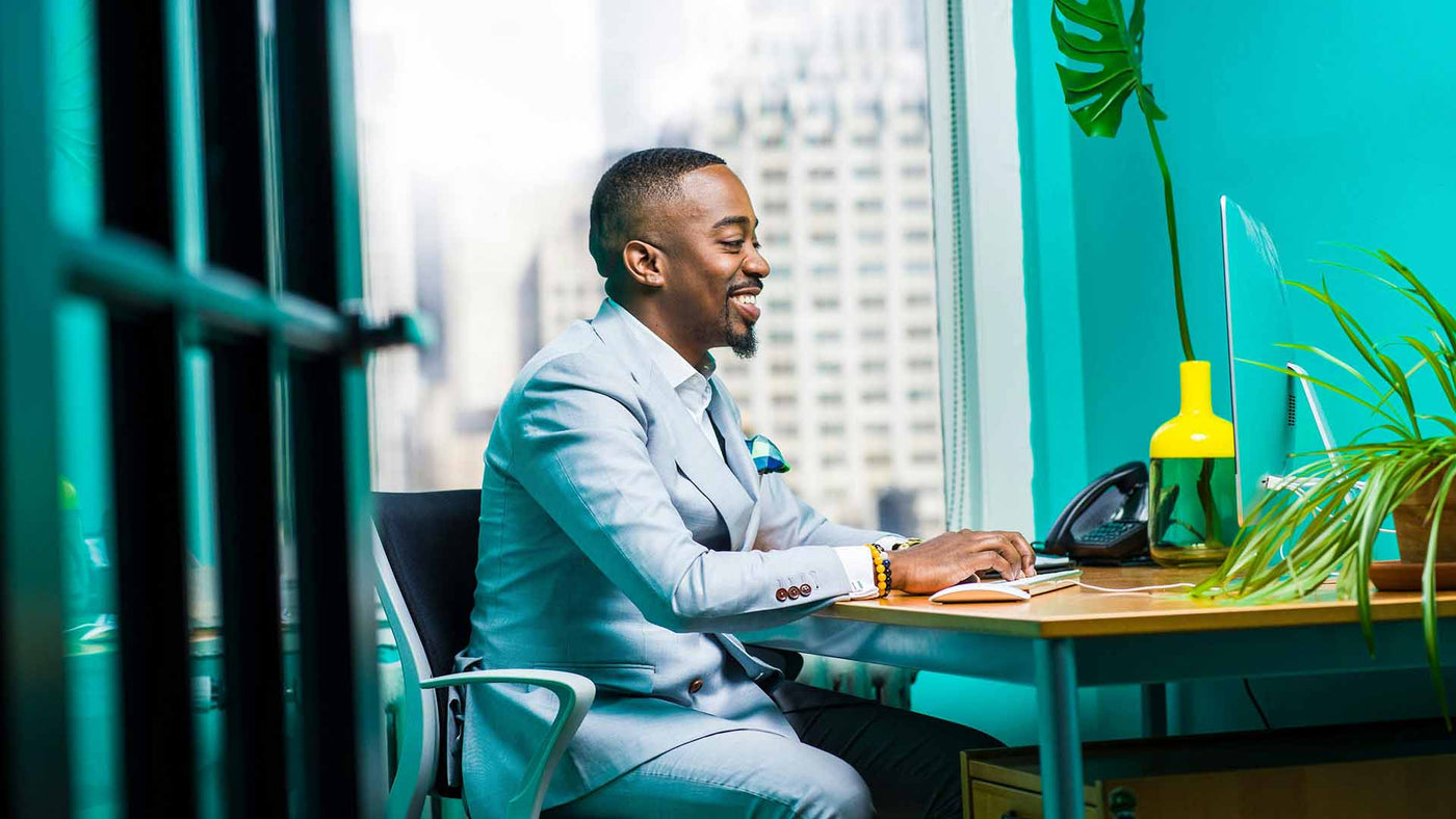 Happy man in a suit working at a computer