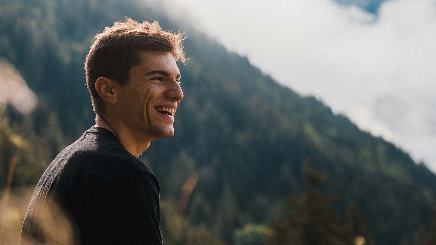 smiling man with mountains in background