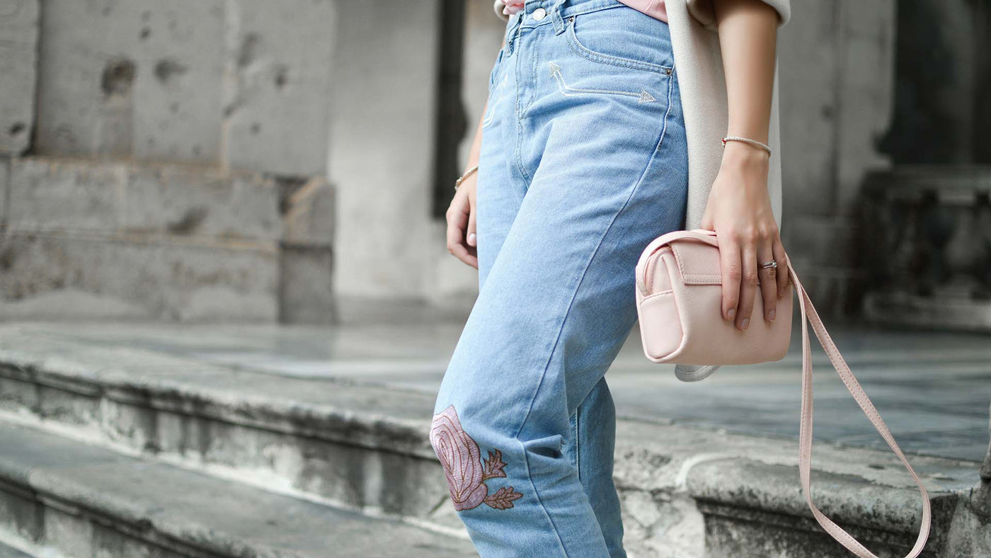 person walking down stairs holding a small purse