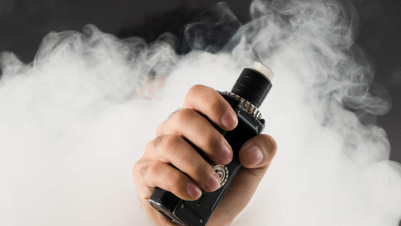 A hand holding a vape
