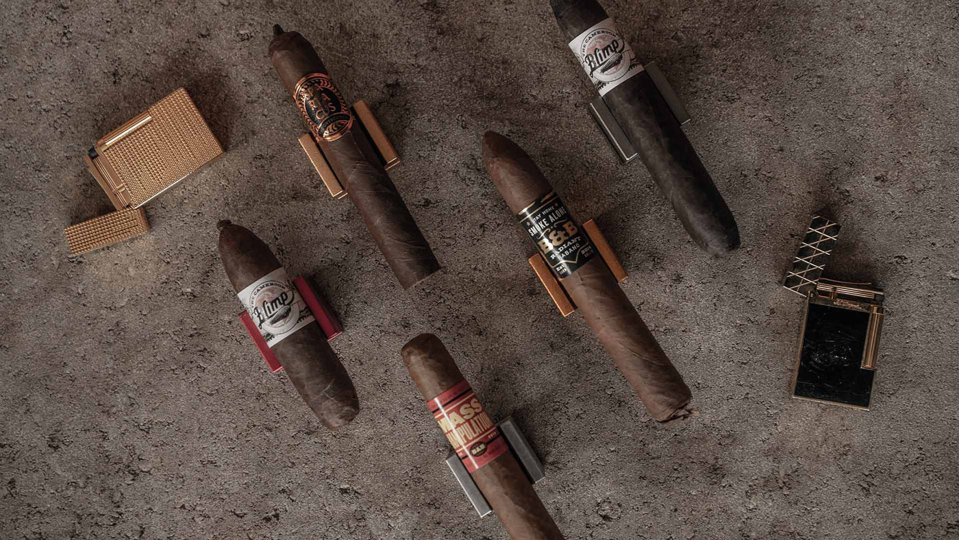 several cigars and lighters scattered on a cement surface