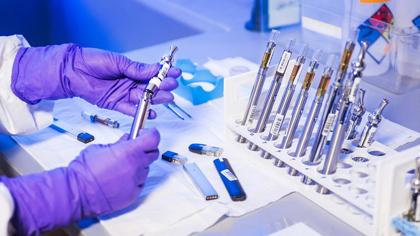 Person examining vape in lab setting